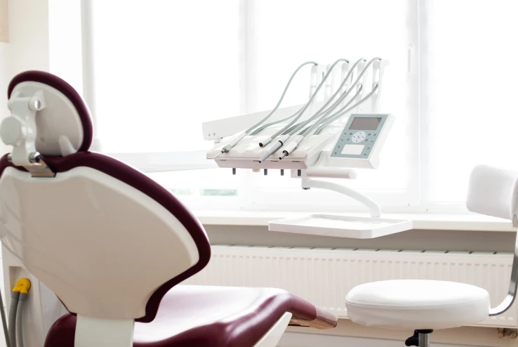 Consultoria com uma cadeira e na frente um aparelho de odontologia